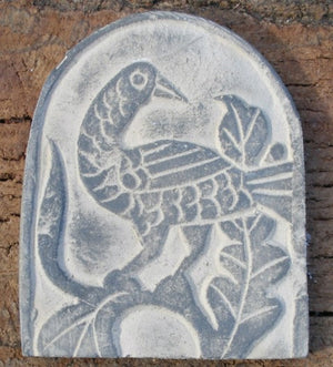 Raised bird carving on a half circle background all grey